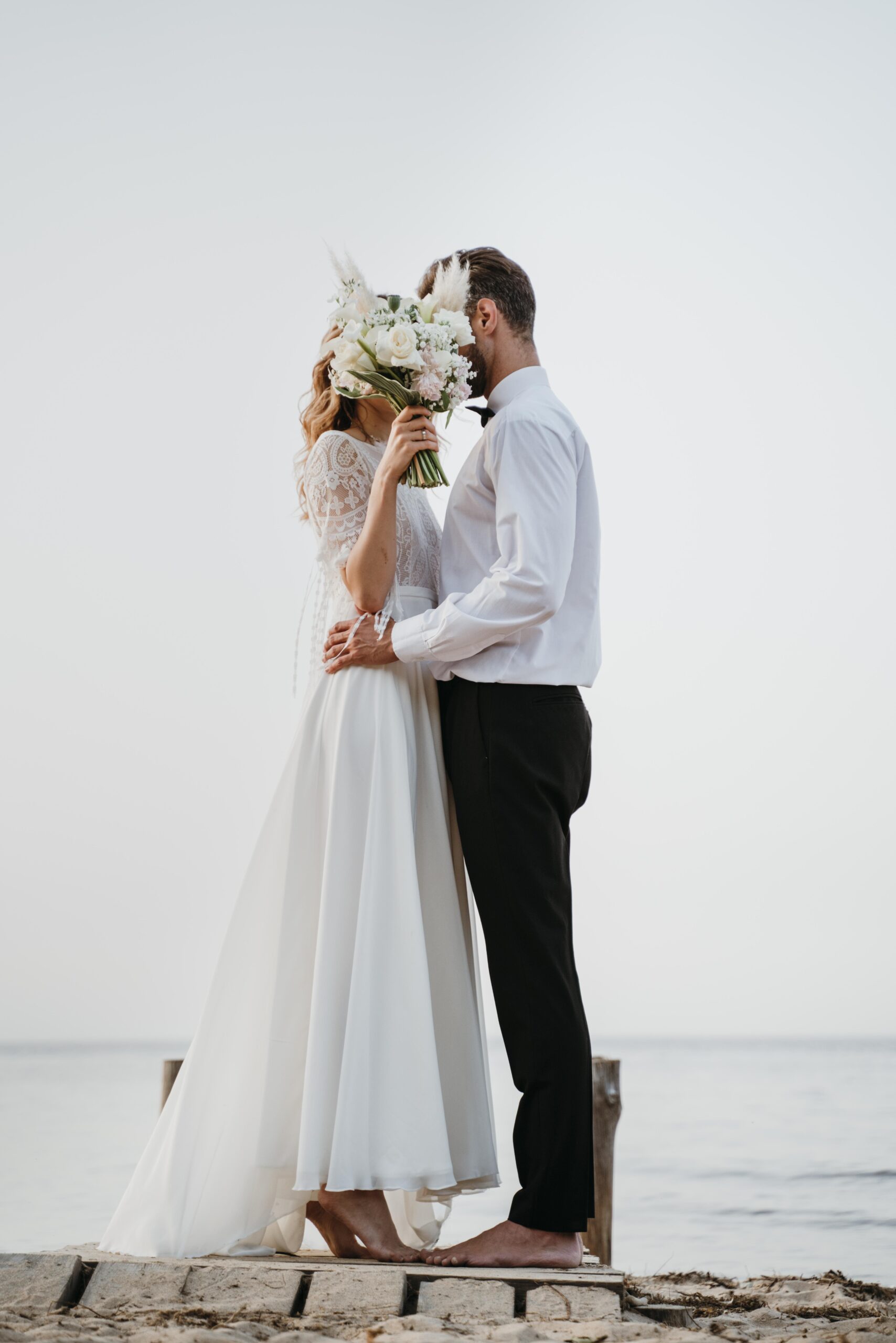 photo-mariage-beau-couple-cacher-par-bouquet-plage